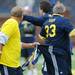 Joe O'Donnell grabs on to Dave FIsher's shorts during the Victors Classic alumni football game at Michigan Stadium on Saturday. Melanie Maxwell I AnnArbor.com